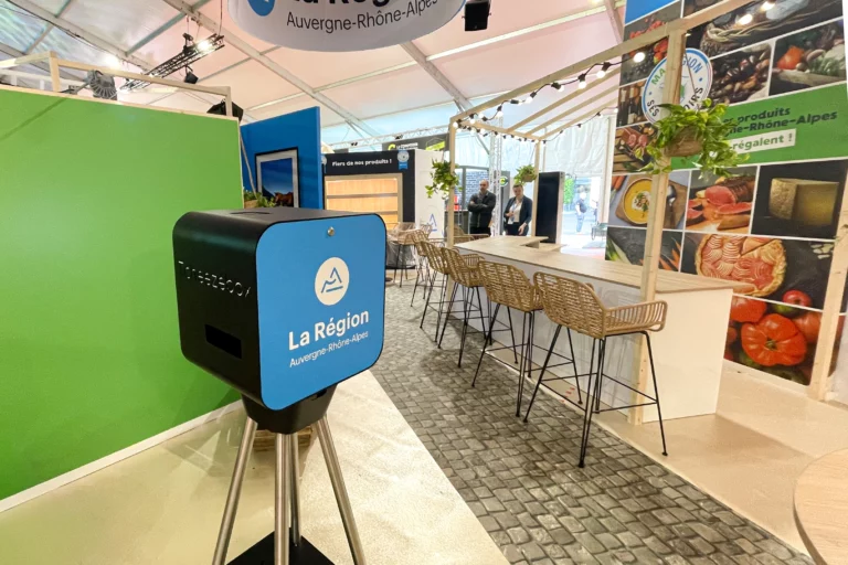 Animation photo immersive sur un stand de salon professionnel en France et en Suisse, avec photobooth personnalisé et visiteurs en interaction.